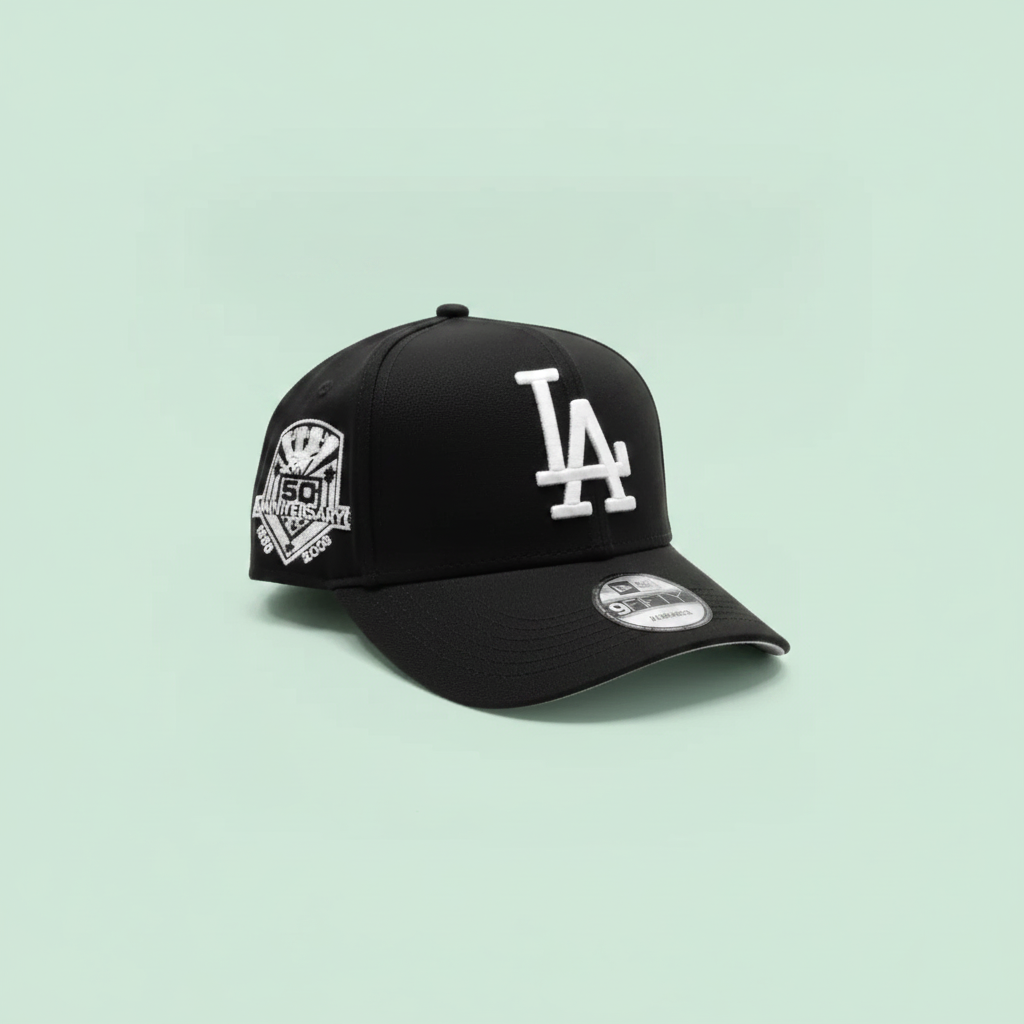 Black embroidered baseball cap left side view on a pastel mint green background