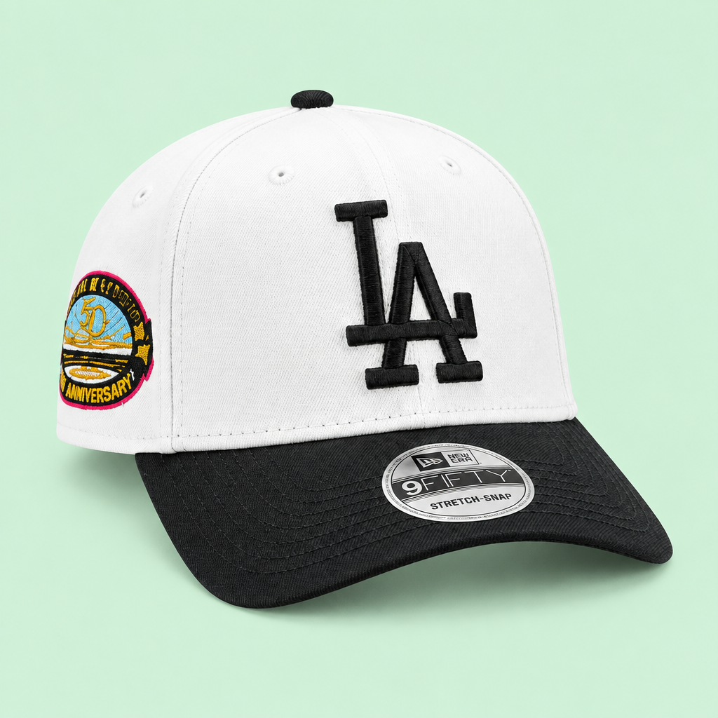 White cap with black brim and raised embroidery, left three-quarter angle on pastel mint-green background