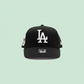Black embroidered baseball cap front view on a pastel mint green background