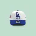White and blue embroidered baseball cap front view on a pastel mint green background