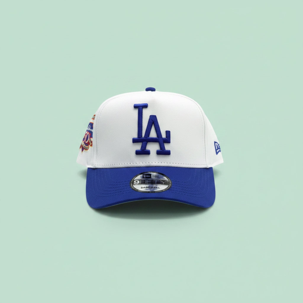 White and blue embroidered baseball cap front view on a pastel mint green background