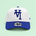 White cap with blue brim, low front view on pastel mint background
