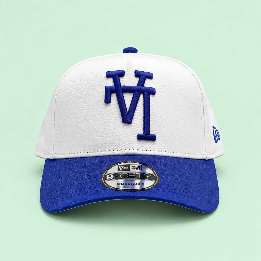 White cap with blue brim, low front view on pastel mint background