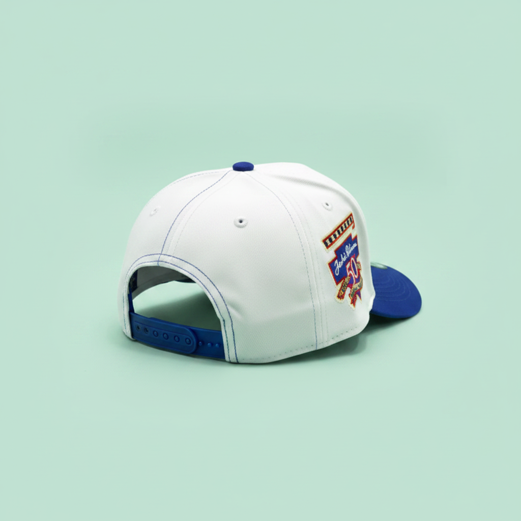 White and blue embroidered baseball cap rear side three-quarter view on a pastel mint green background