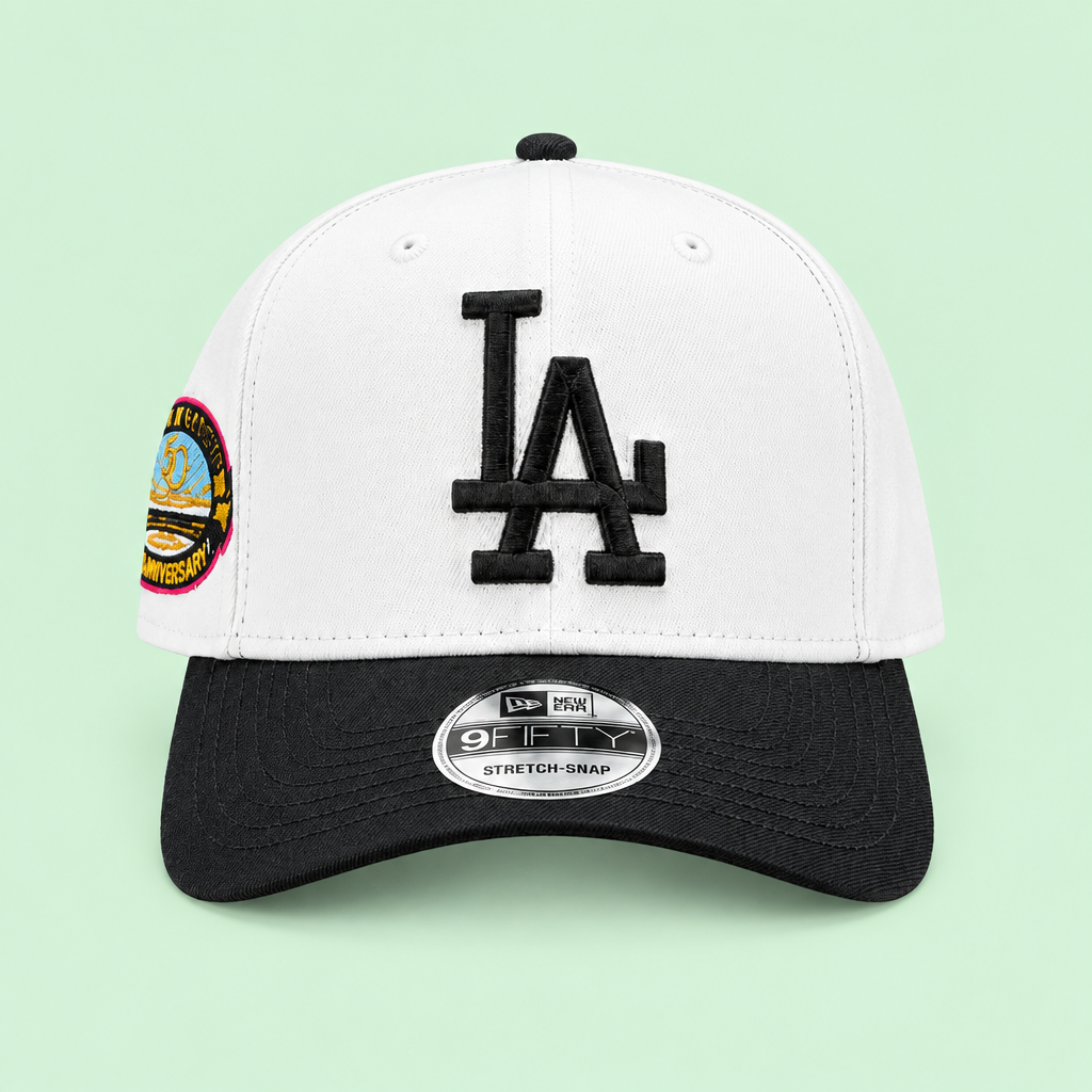 White cap with black brim and raised embroidery, straight-on front angle on pastel mint-green background
