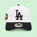 White cap with black brim and raised embroidery, straight-on front angle on pastel mint-green background