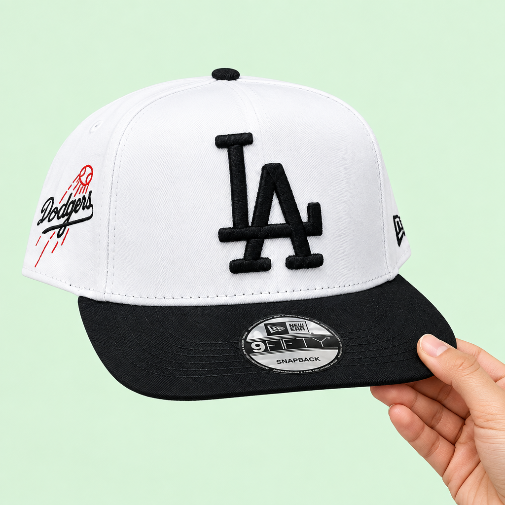 White-and-black snapback cap held in one hand, side-forward view